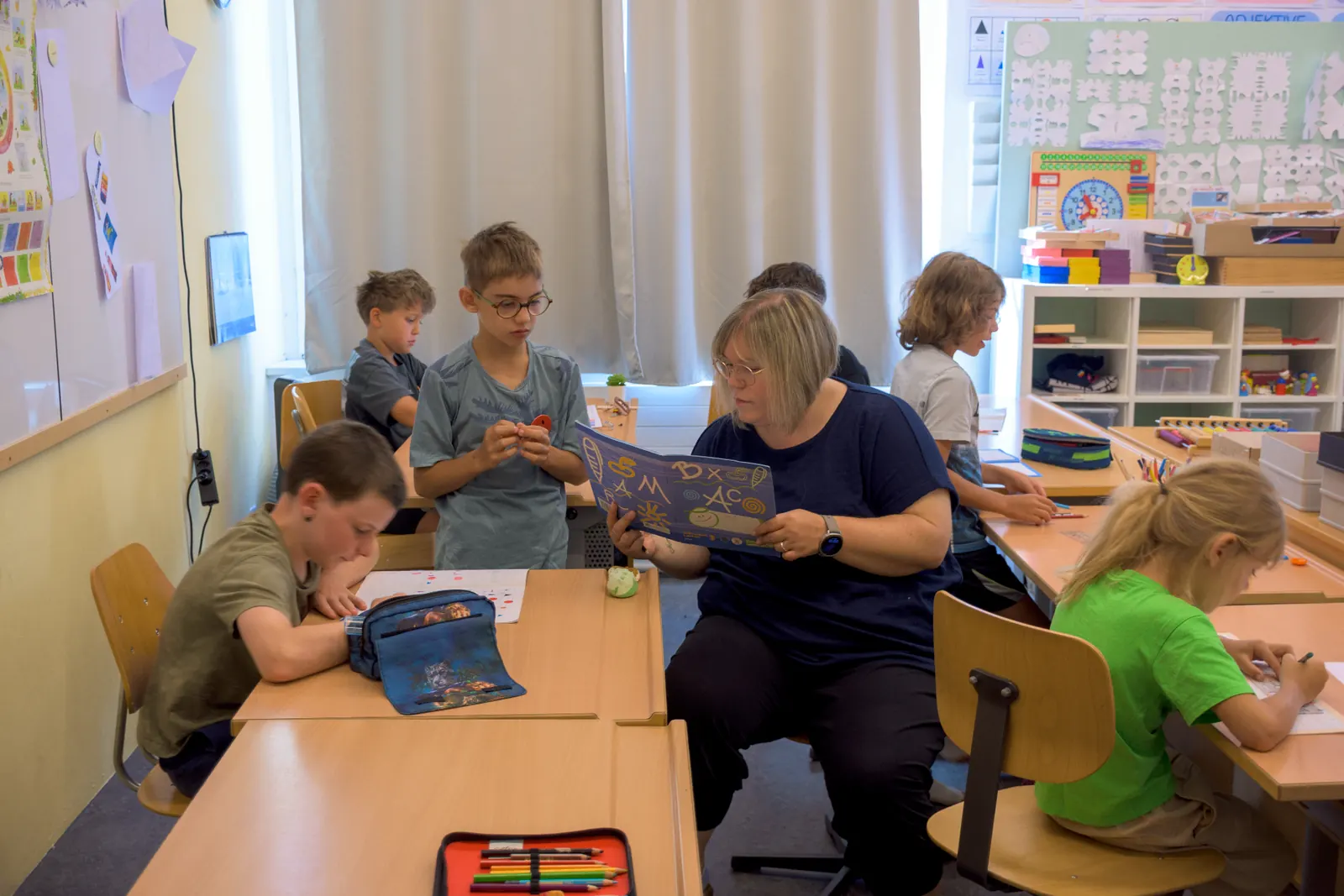 Lehrperson begleitet Schülerinnen und Schüler im Unterricht der Giraffen.Schule