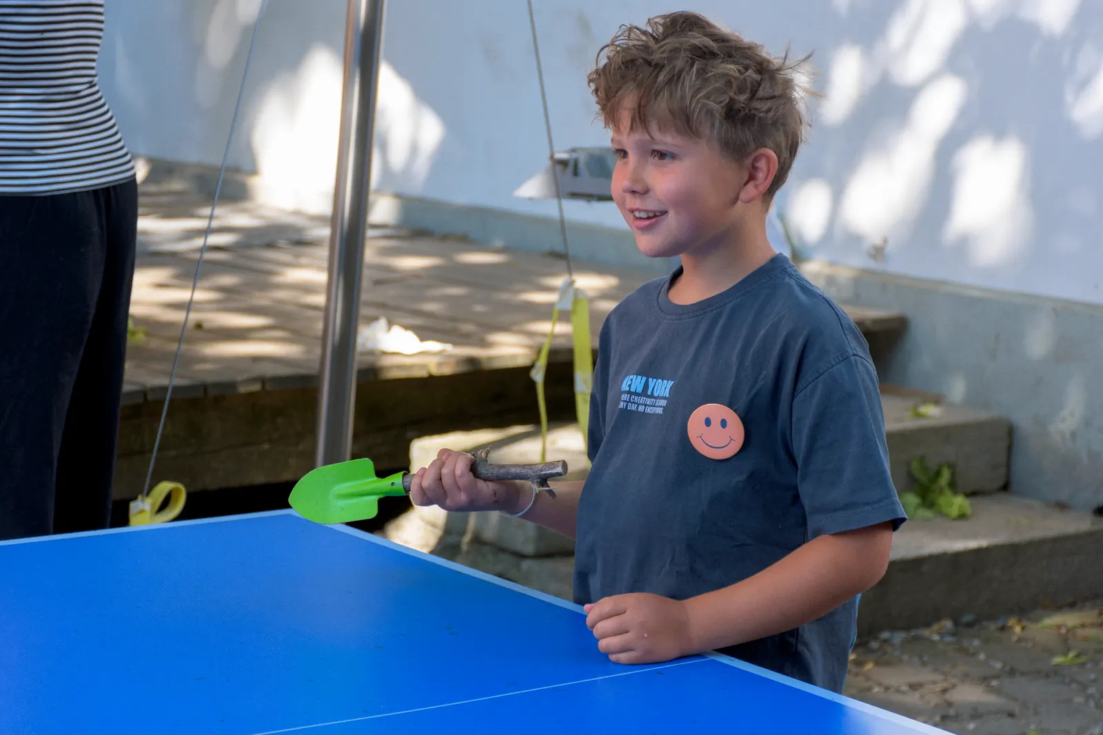 Kind spielt draussen an der Tischtennisplatte